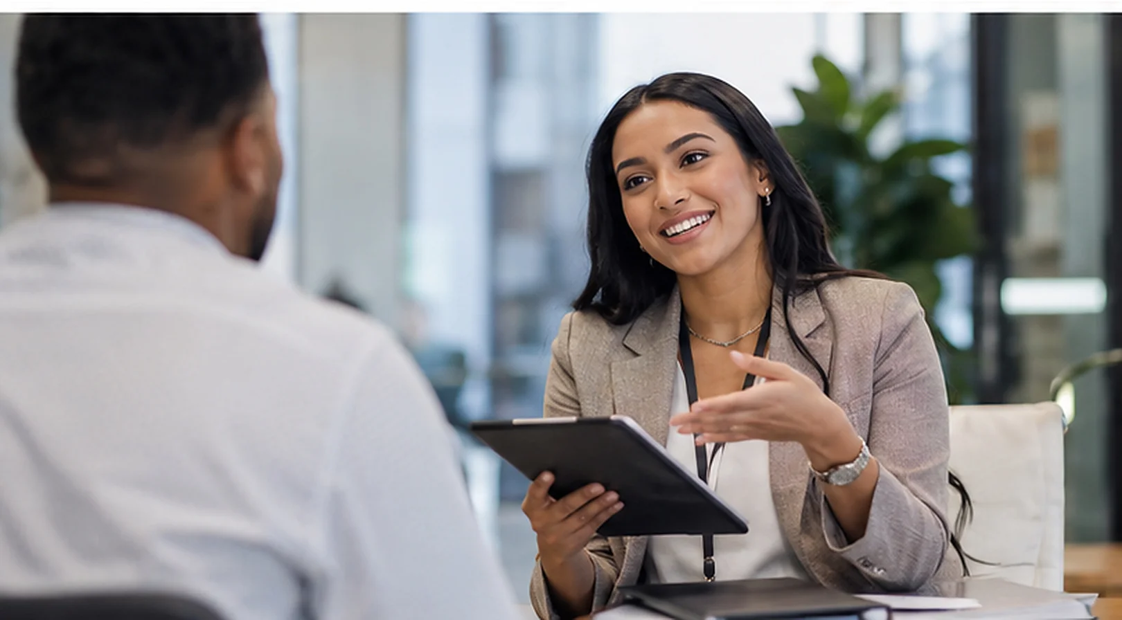 A recruiter speaking with a candidate across a desk.